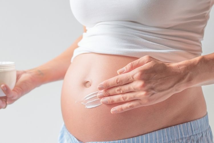 Woman cares for her stretch marks on belly